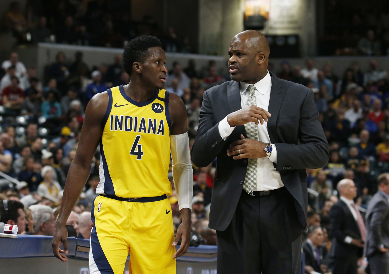 Victor Oladipo and Nate McMillan chatting during a game