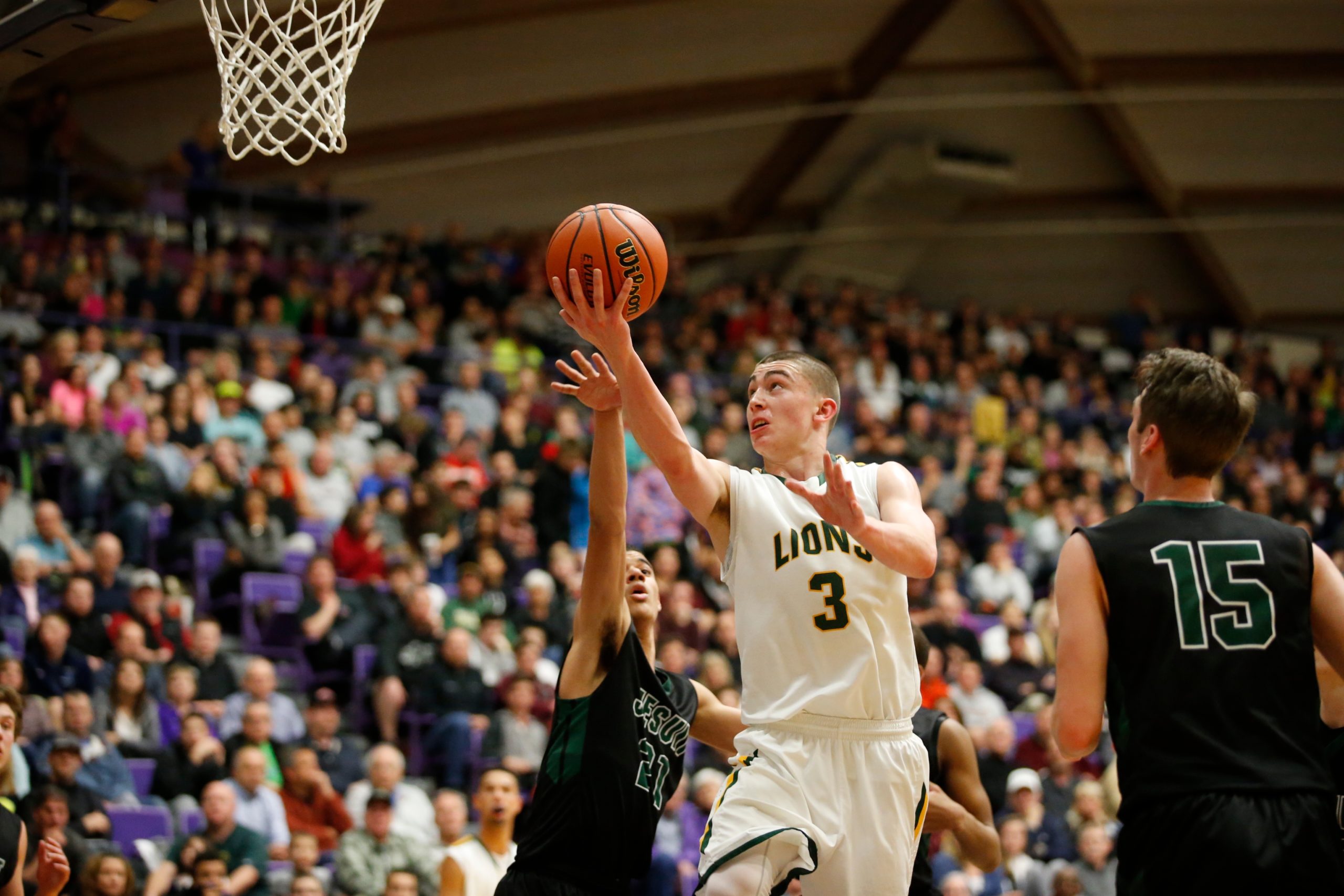 West Linn's Payton Pritchard drives on Jesuit's Malcolm Porter as Jesuit plays West Linn for the 6A Basketball State Championship at the Chiles Center in Portland, Ore. on Saturday, March 14, 2015. 